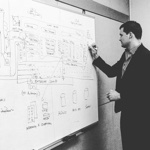 Thomas Prommer designing system architecture on whiteboard